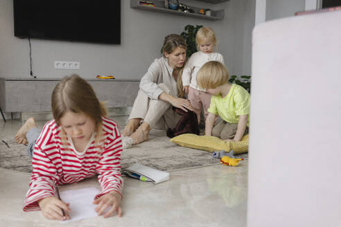 Kinder, die mit ihrer Mutter spielen, und ein Mädchen, das zu Hause Hausaufgaben macht - SEAF02232