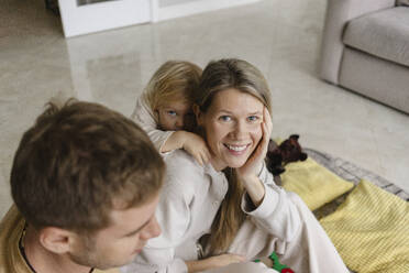 Lächelnde Frau sitzt mit ihrem Sohn zu Hause auf dem Boden - SEAF02236