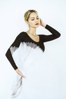 Elegante Balletttänzerin mit weißem Tutu steht im Studio - YHF00098