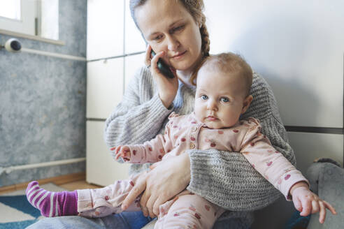 Baby-Mädchen mit Mutter im Gespräch über Smartphone zu Hause - IHF01876
