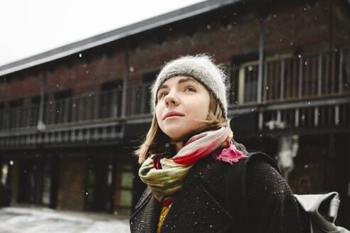 Thoughtful young woman in front of building - EYAF02949