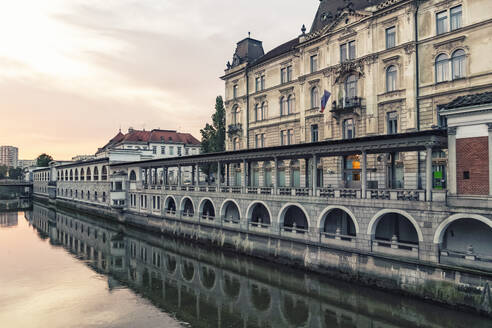 Slowenien, Ljubljana, Fluss Ljubljanica und Gebäude des Zentralmarktes in der Morgendämmerung - TAMF04214
