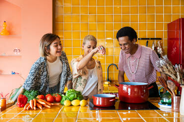 Group of friends bonding at home, LGBTQ and diversity concepts - Homosexual couple and fluid gender non binary young man with cross dressing clothing style having fun in the apartment, LGBT people concepts - DMDF09382