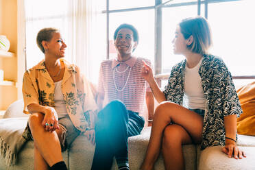 Group of friends bonding at home, LGBTQ and diversity concepts - Homosexual couple and fluid gender non binary young man with cross dressing clothing style having fun in the apartment, LGBT people concepts - DMDF09394