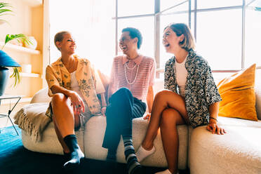 Group of friends bonding at home, LGBTQ and diversity concepts - Homosexual couple and fluid gender non binary young man with cross dressing clothing style having fun in the apartment, LGBT people concepts - DMDF09395