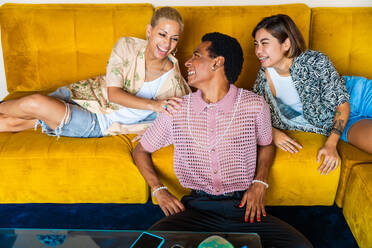 Group of friends bonding at home, LGBTQ and diversity concepts - Homosexual couple and fluid gender non binary young man with cross dressing clothing style having fun in the apartment, LGBT people concepts - DMDF09432