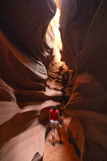 A girl enjoys the beautiful view of the Upper Antelope Canyon on a sunny summer day, Page, Arizona, United States of America, North America - RHPLF31687