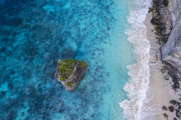 Luftaufnahme von Suwehan weißer Sandstrand mit türkisfarbenem Meerwasser und dem großen Felsen (Meeresstapel) im Meer von einer Drohne aus gesehen, Nusa Penida, Klungkung regency, Bali, Indonesien, Südostasien, Asien - RHPLF31920