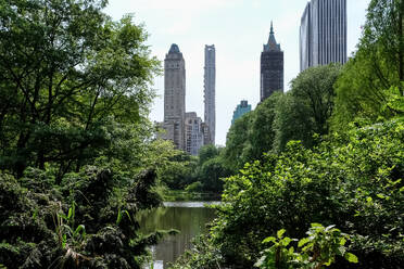 Blick auf das Stadtbild von Manhattan von The Pond aus gesehen, einem der sieben Gewässer im Central Park in der Nähe des Grand Army Plaza, gegenüber dem Central Park South vom Plaza Hotel, New York City, Vereinigte Staaten von Amerika, Nordamerika - RHPLF31995