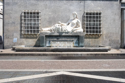 View of the Fountain of Dora in Via Roma, executed by Umberto Baglion, 1893-1965, and placed in 1939, the allegorical statue represents the River Dora with a woman lying on a pedestal, from which water flows, Turin, Piedmont, Italy, Europe - RHPLF32005