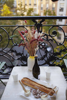 Vase mit Weinflasche und Essen auf dem Balkon - DANF00001