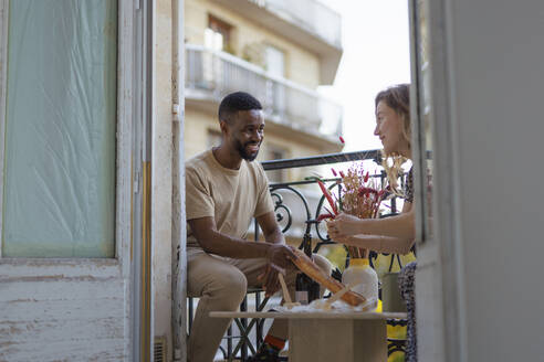 Glücklicher Mann und Frau beim Mittagessen auf dem Balkon - DANF00011