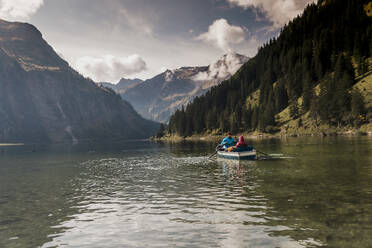 Couple riding in boat at lake Vilsalpsee near mountains, Tyrol, Austria - UUF31089