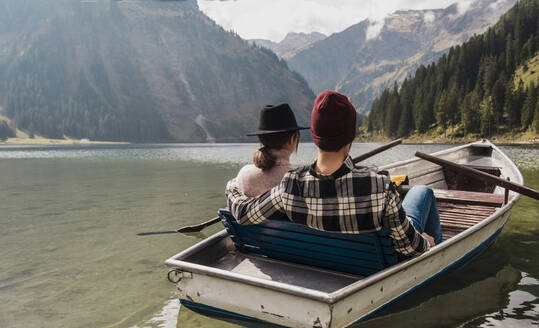 Junges Paar sitzt in einem Boot auf dem Vilsalpsee in der Nähe der Berge, Tirol, Österreich - UUF31090