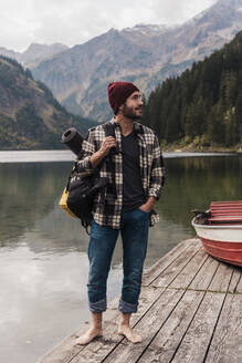 Junger Mann steht auf einem Steg am Vilsalpsee in Tirol, Österreich - UUF31095