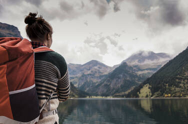 Woman with backpack in front of lake Vilsalpsee and mountains at Tyrol, Austria - UUF31102