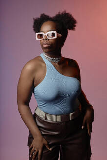 Frau mit blauem Oberteil und Sonnenbrille vor einem Hintergrund mit Farbverlauf - KPEF00600