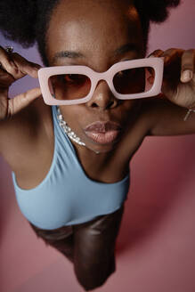 Junge Frau posiert mit Sonnenbrille - KPEF00604