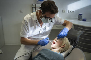 Zahnarzt bei der Untersuchung eines Patienten mit medizinischen Geräten in einer Klinik - NJAF00745