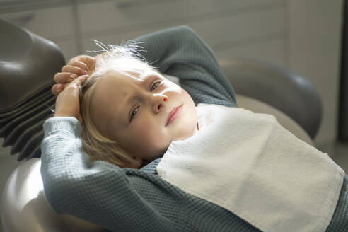 Boy lying on chair to get dental treatment in clinic - NJAF00747