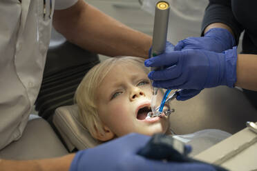 Zahnarzt behandelt Patient mit Assistentin in der Klinik - NJAF00748