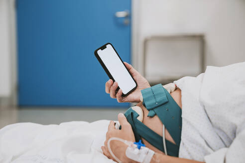 Pregnant woman using smart phone in hospital - EBBF08348