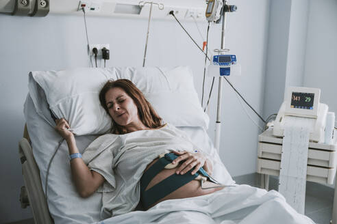 Schwangere Frau mit Schmerzen auf dem Bett im Krankenhaus - EBBF08355