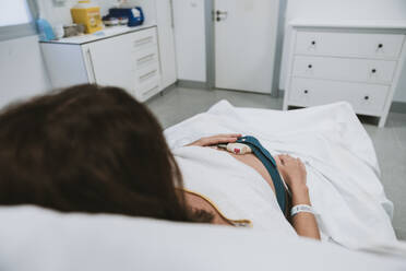 Schwangere Frau auf dem Bett liegend im Krankenhaus - EBBF08366