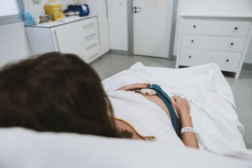 Pregnant woman lying on bed in hospital - EBBF08366