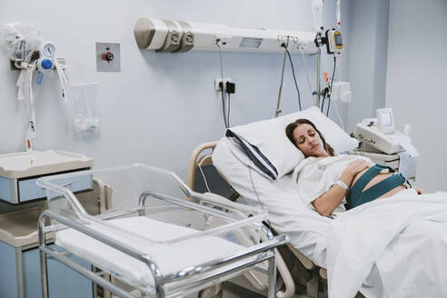 Schwangere Frau auf dem Bett im Kreißsaal liegend - EBBF08370