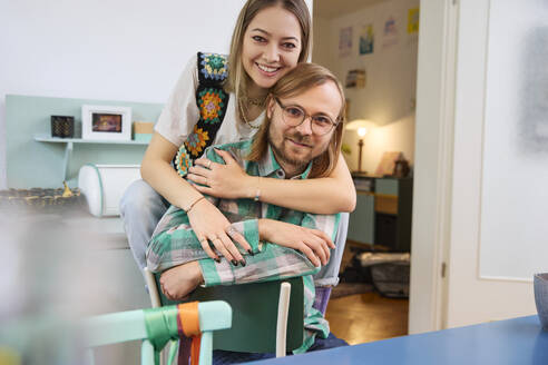 Happy man and woman sitting together at home - SUF00723