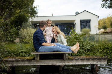 Happy family enjoying together on jetty - JOSEF23205