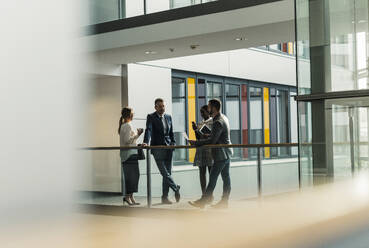 Business colleagues having discussion on walkway - UUF31120