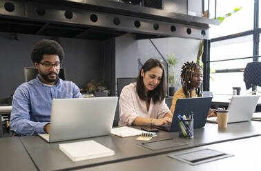 Geschäftsleute arbeiten an Laptops am Schreibtisch - VRAF00356