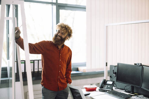 Happy businessman giving presentation in office - JOSEF23330