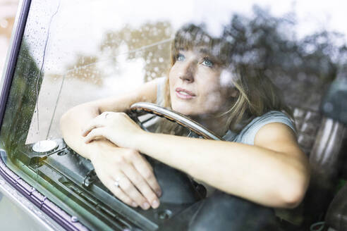 Nachdenkliche schöne Frau schaut durch ein Autofenster - WPEF08260