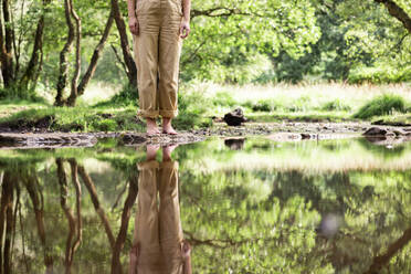 Frau steht auf einem Felsen im Fluss - WPEF08355