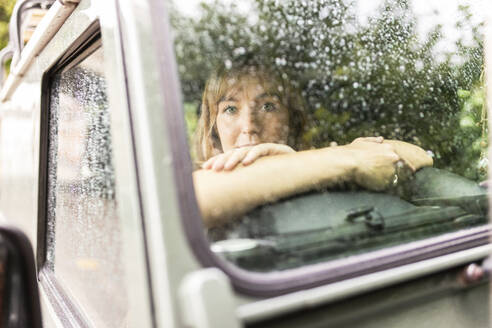 Young woman sitting in car - WPEF08377