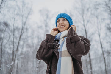 Smiling woman wearing knit hat in winter - ANAF02700