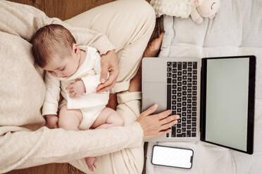 Freiberufler arbeitet am Laptop, während die kleine Tochter zu Hause schläft - EBBF08398