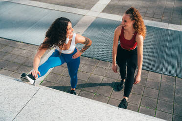 Ein schwules Paar trainiert zusammen im Freien. Ein echtes Läuferpaar treibt Sport in einem urbanen Gebiet der Stadt. Konzepte von Sport und Lifestyle - DMDF09828