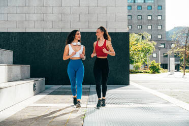 Lgbt couple training together outdoor. Runner real couple making sport in an urban area of the city. Concepts of sports and lifestyle - DMDF09835