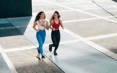 Ein schwules Paar trainiert zusammen im Freien. Ein echtes Läuferpaar treibt Sport in einem urbanen Gebiet der Stadt. Konzepte von Sport und Lifestyle - DMDF09837