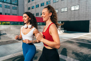 Lgbt couple training together outdoor. Runner real couple making sport in an urban area of the city. Concepts of sports and lifestyle - DMDF09841