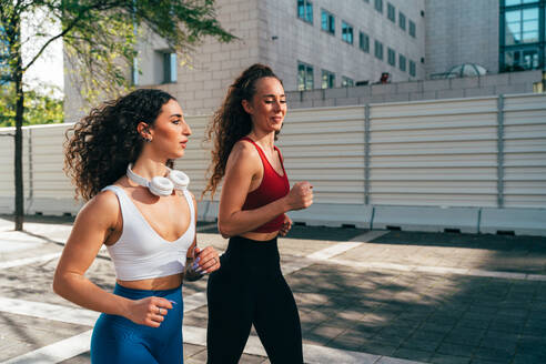 Ein schwules Paar trainiert zusammen im Freien. Ein echtes Läuferpaar treibt Sport in einem urbanen Gebiet der Stadt. Konzepte von Sport und Lifestyle - DMDF09842