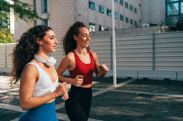 Lgbt couple training together outdoor. Runner real couple making sport in an urban area of the city. Concepts of sports and lifestyle - DMDF09843