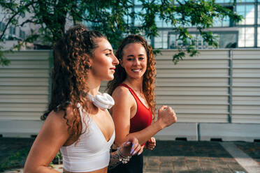 Ein schwules Paar trainiert zusammen im Freien. Ein echtes Läuferpaar treibt Sport in einem urbanen Gebiet der Stadt. Konzepte von Sport und Lifestyle - DMDF09846