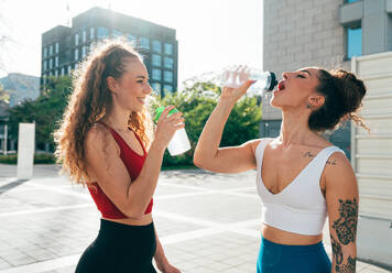 Ein schwules Paar trainiert zusammen im Freien. Ein echtes Läuferpaar treibt Sport in einem urbanen Gebiet der Stadt. Konzepte von Sport und Lifestyle - DMDF09851