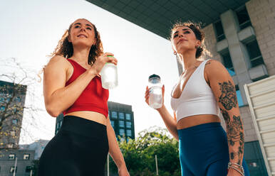 Ein schwules Paar trainiert zusammen im Freien. Ein echtes Läuferpaar treibt Sport in einem urbanen Gebiet der Stadt. Konzepte von Sport und Lifestyle - DMDF09852