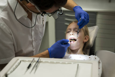 Zahnarzt bei der zahnärztlichen Untersuchung eines Mädchens in einer medizinischen Klinik - NJAF00761